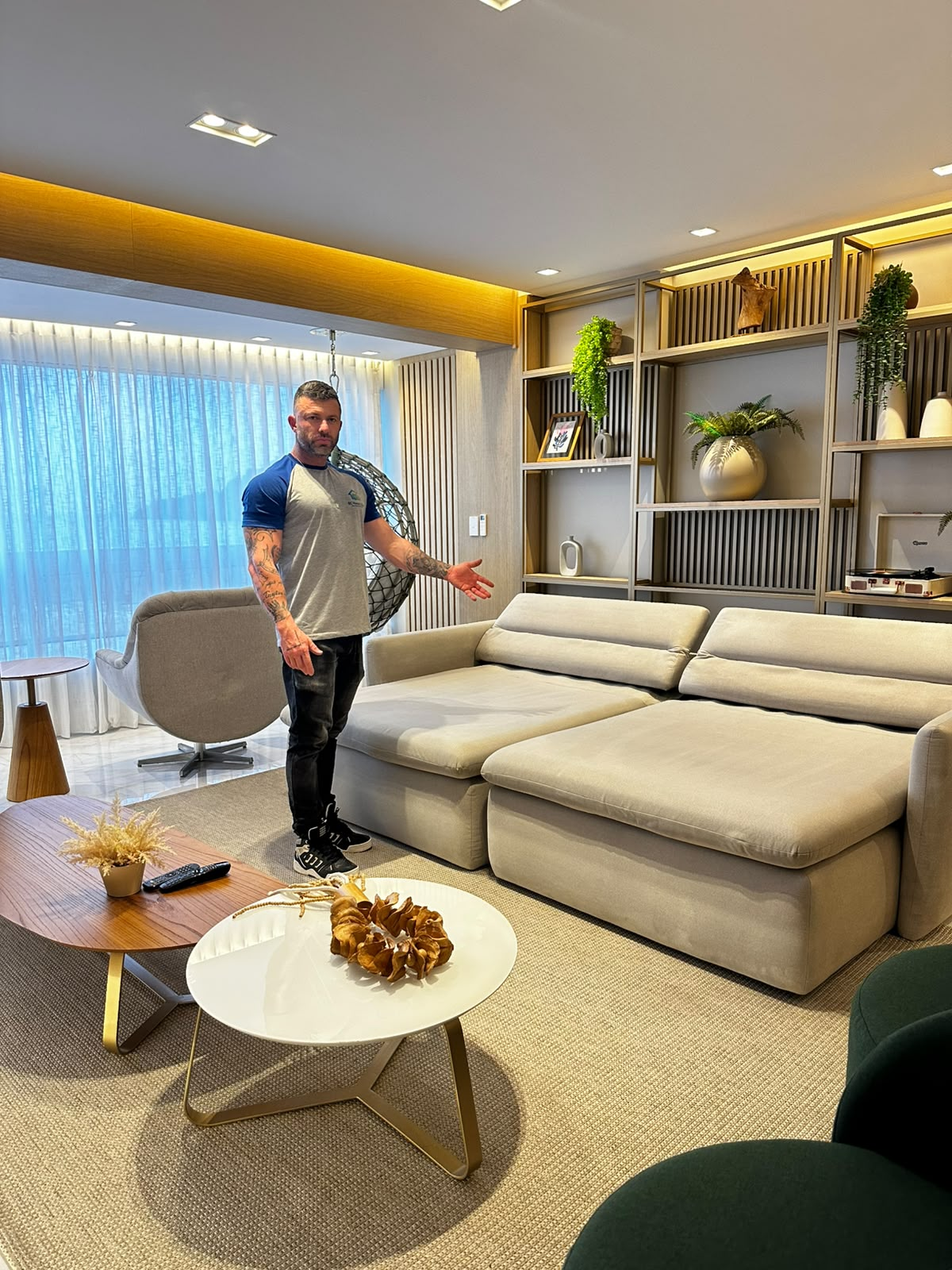 Profissional da BC Home Clean ao lado de um sofá em uma sala